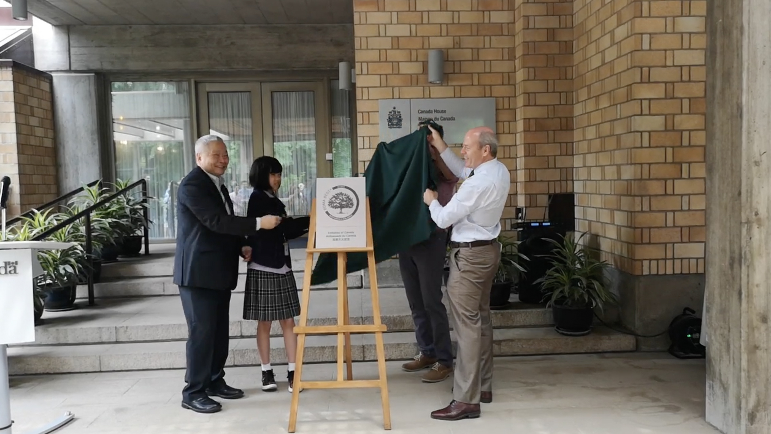 BOMA BEST - A group of people standing in front of the Canadian Embassy building, celebrating its BOMA BEST Silver Certification.