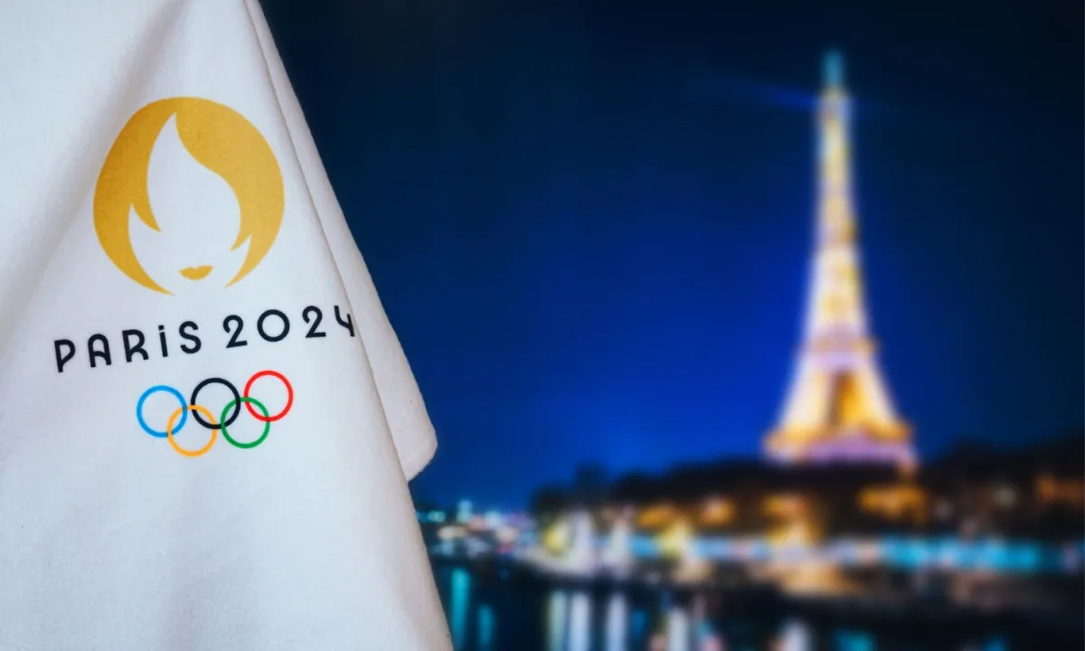 BOMA BEST - A cloth with the gold Paris 2024 Olympics logo is shown against a backdrop of the illuminated Eiffel Tower at night.